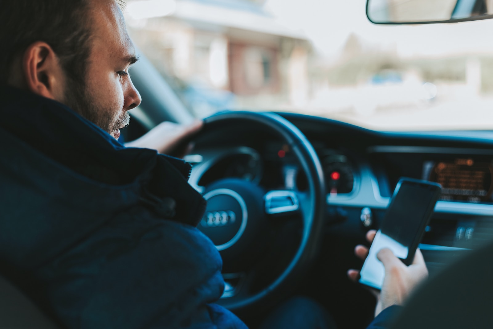 man holding black smartphone checking his SR-22 insurance